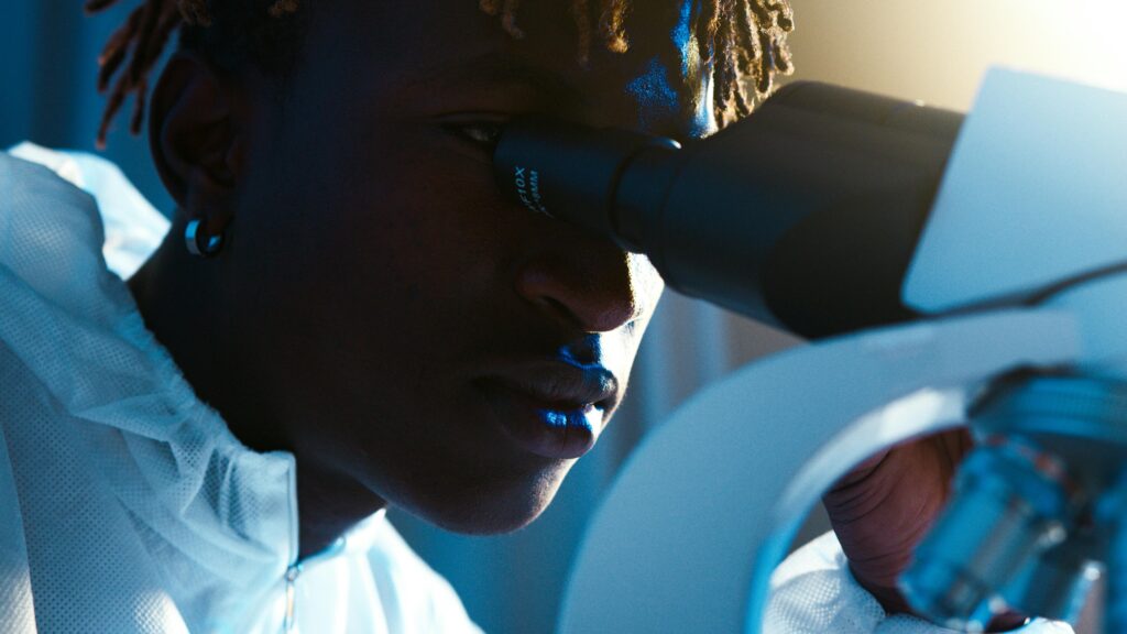 A Man Looking Through the Microscope